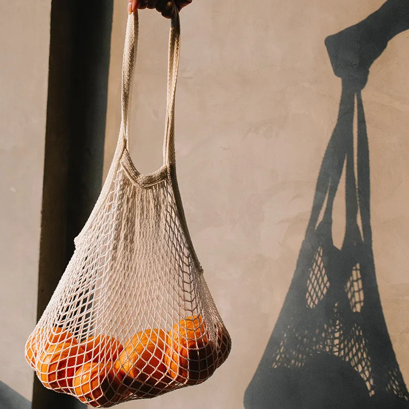 Model holding cotton grocery tote with oranges